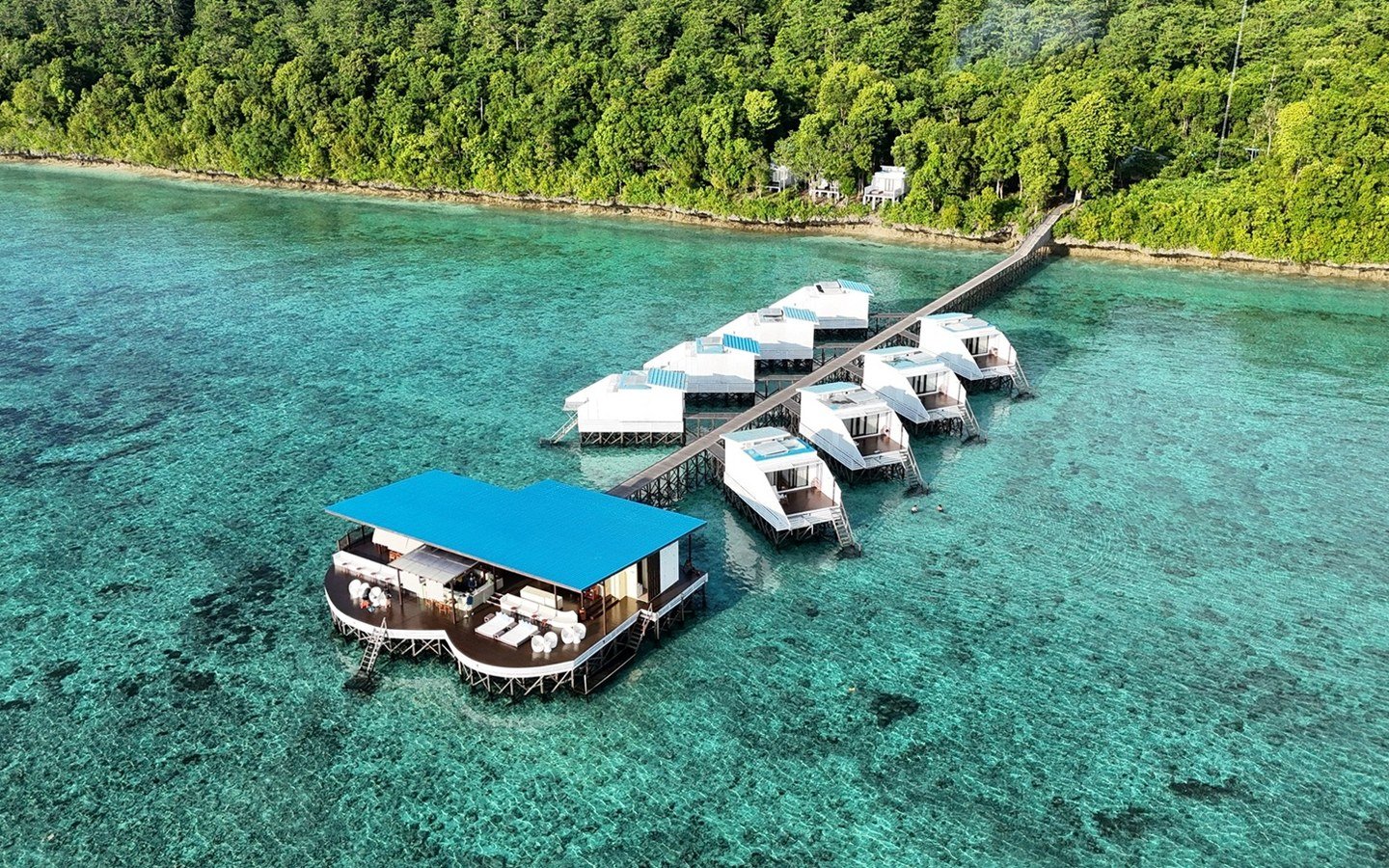 Aerial view of Samamea and Arasatu's Floating Villas above clear coral-rich water.