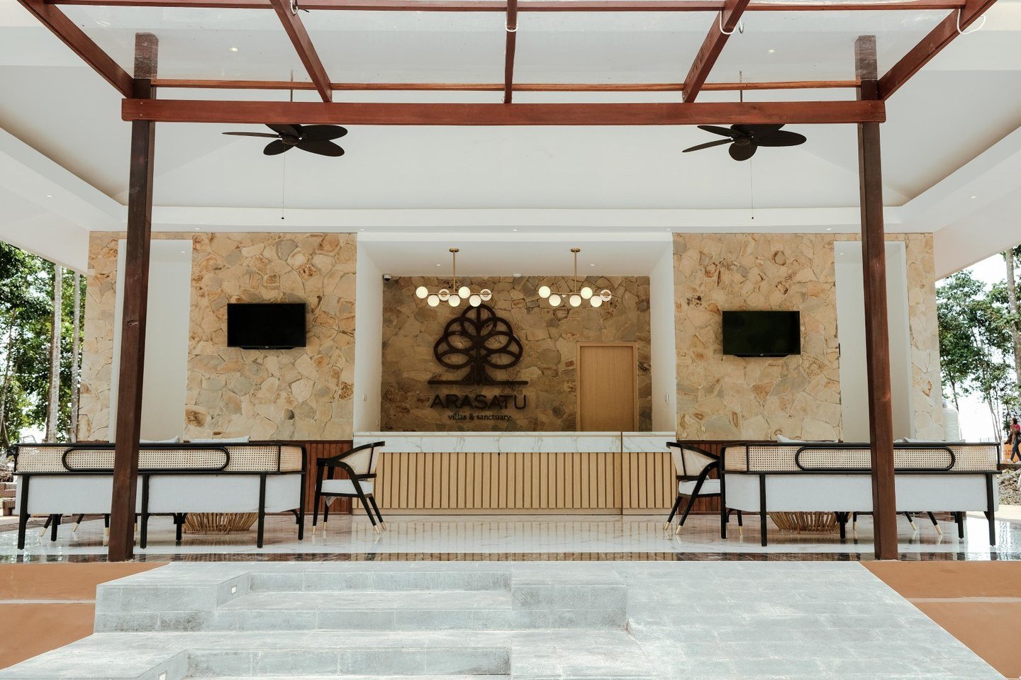 The Arasatu lobby and reception framed by warm timber and stone.