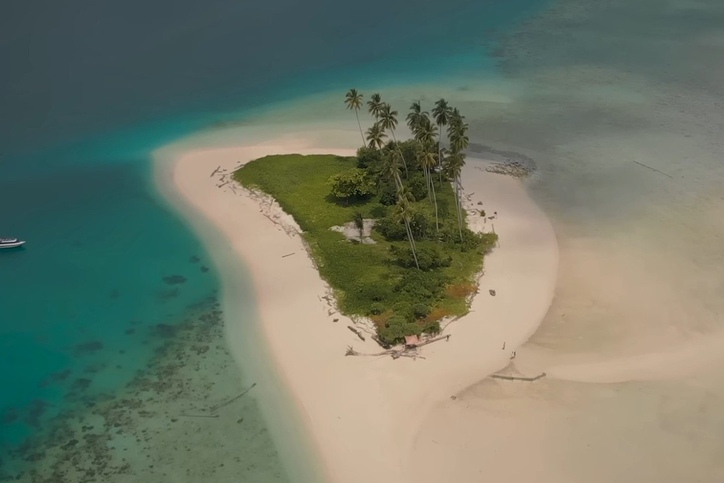 Aerial view of Manimbora Island surrounded by shallow blue water.